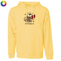 A pale yellow pullover hoodie with a front kangaroo pocket and a central graphic of a dog wearing sunglasses and a brown jacket, reading a red book, with the text 'all booked up' below. A small multicolor color wheel icon is in the top-left corner.