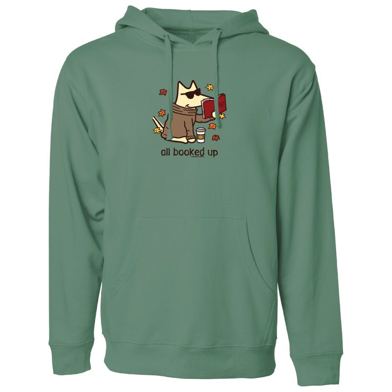 A sage green pullover hoodie featuring a cartoon graphic of a cat wearing sunglasses and holding a red mug, surrounded by autumn leaves, with the text 'all booked up' printed below.