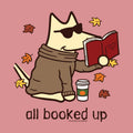 A stylized cartoon dog wearing dark sunglasses and a brown sweater sits on a dusty pink background, reading a red book with autumn leaves floating around it. A takeaway coffee cup appears beside the dog, and the text 'all booked up' appears below.