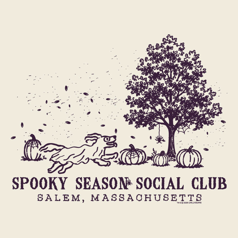 A vintage-style illustrated graphic on a warm cream background featuring a dark plum line drawing of a tree, pumpkins, falling leaves, and a running dog. Text below reads 'SPOOKY SEASON SOCIAL CLUB' and 'SALEM, MASSACHUSETTS.